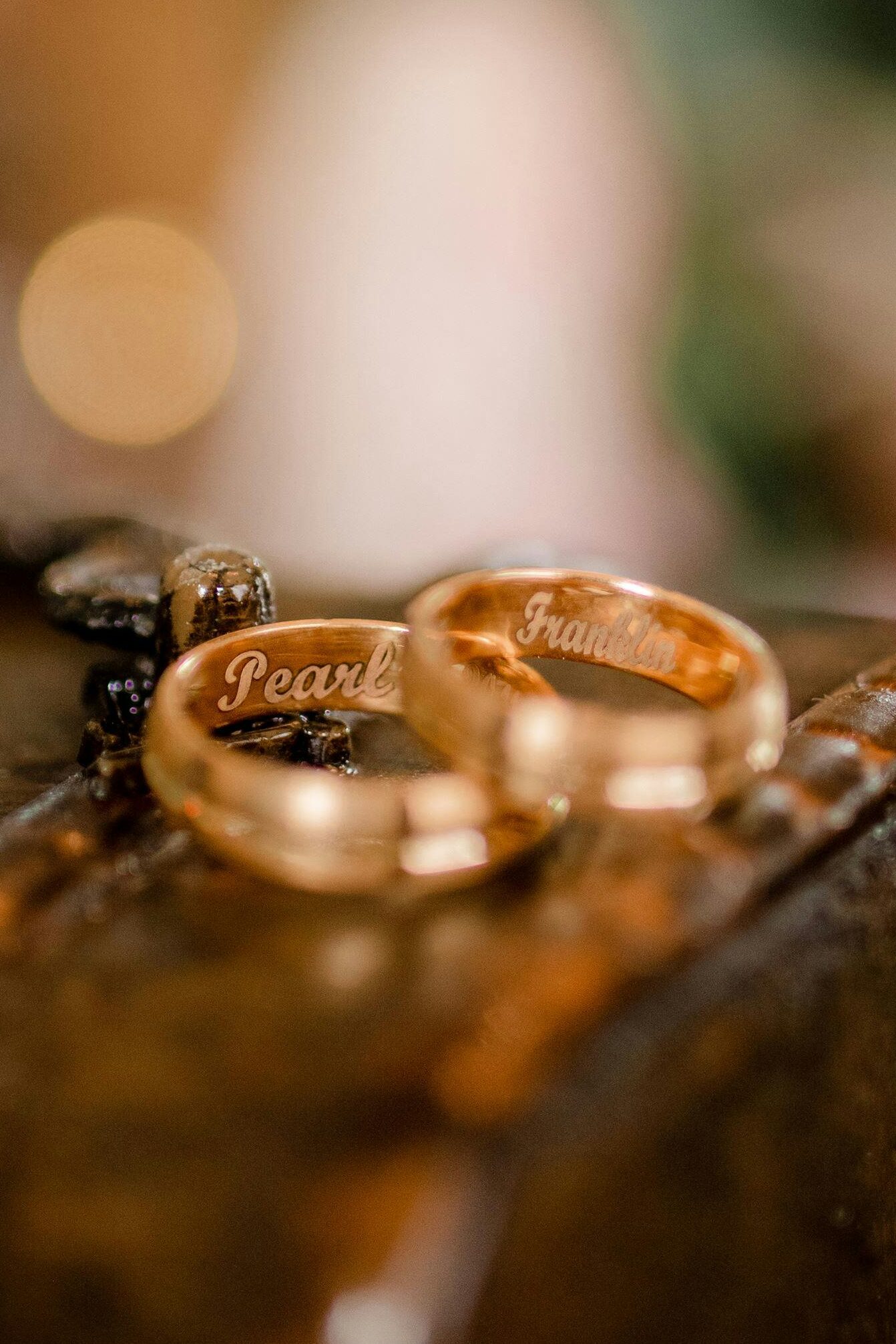 Detailed close-up of engraved wedding rings on leather with elegant bokeh in the background.